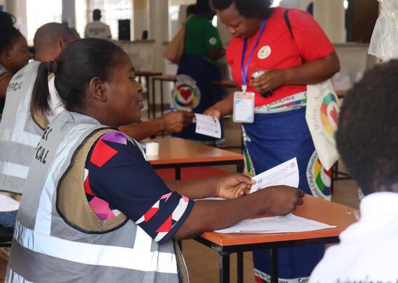 På bildet rettleiar valmedarbeidarane medlemmene før dei skal stemme. Foto: Esther Nyirongo/NONM 2022
