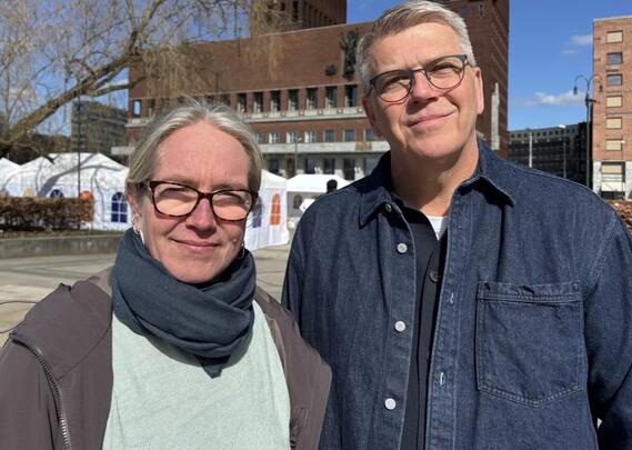 Kvinne med briller og mann med briller står ved siden av hverandre.