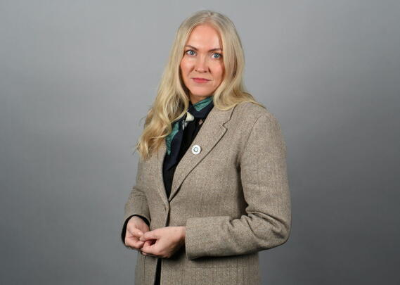 Portrettbilde av alvorlig kvinne med blazer og langt blondt hår.