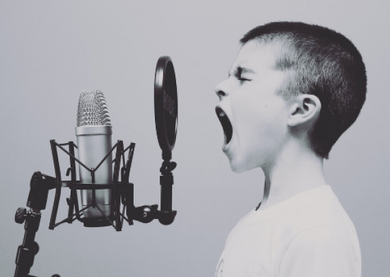 Illustrasjonsbilde av gutt som roper inn i mikrofon