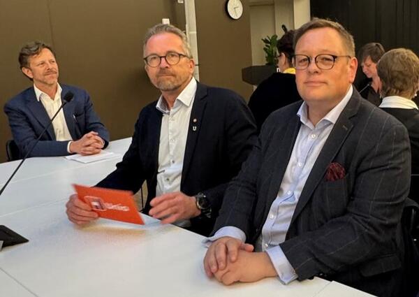 Geir Røsvoll og Kai Øivind Brenden sitter ved et bord og ser inn i kamera.