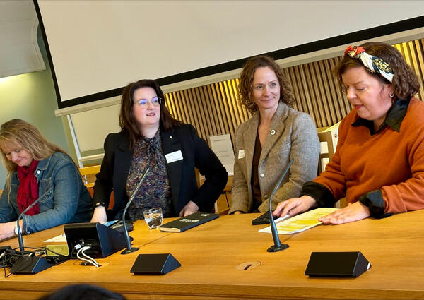 Tre kvinner sitter ved et bord.