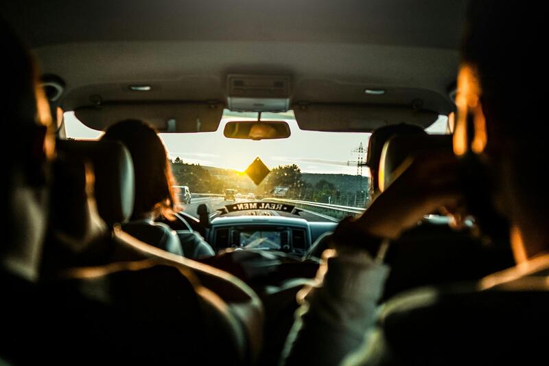 Innsiden av en bil full av passasjerer sett fra baksetet.