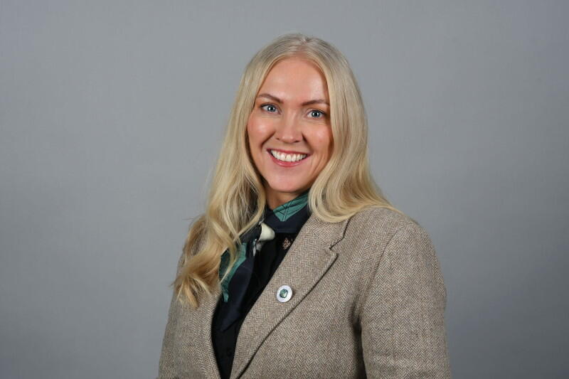 Portrettbilde av smilende kvinne med langt lyst hår.