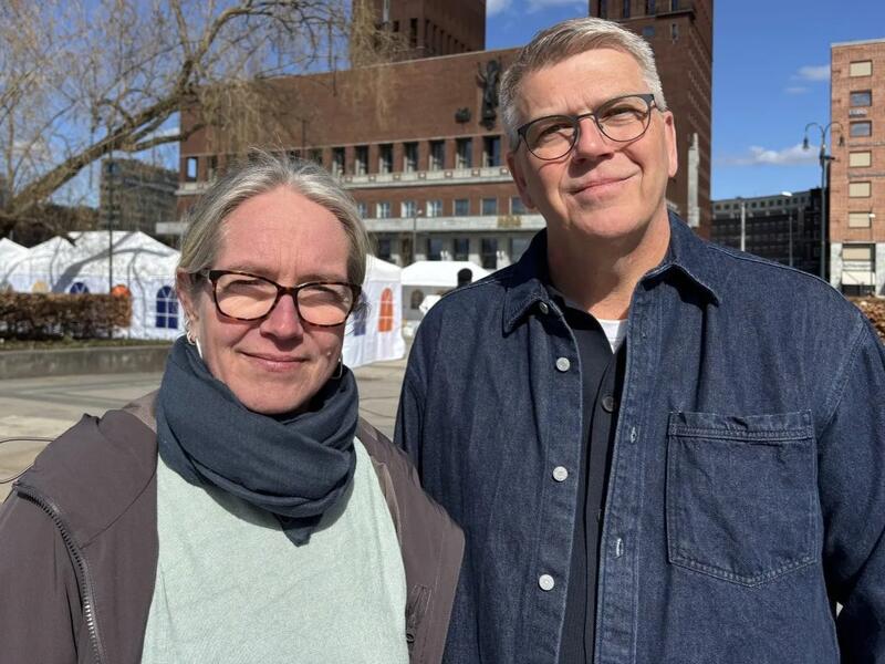 Kvinne med briller og mann med briller står ved siden av hverandre.