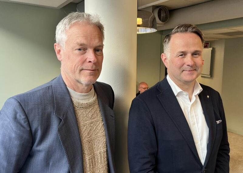 To med med dressjakke ser mot fotografen.
